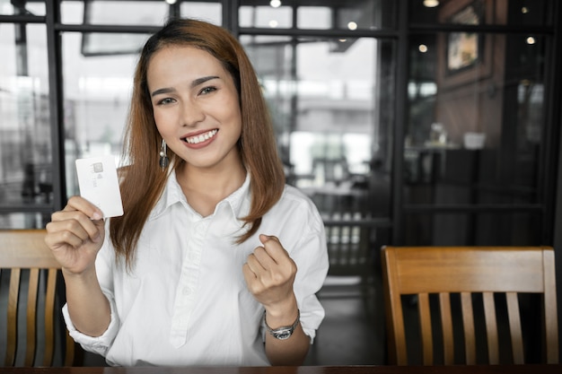 女性はオンラインでカードとコンピュータで買い物をしています。