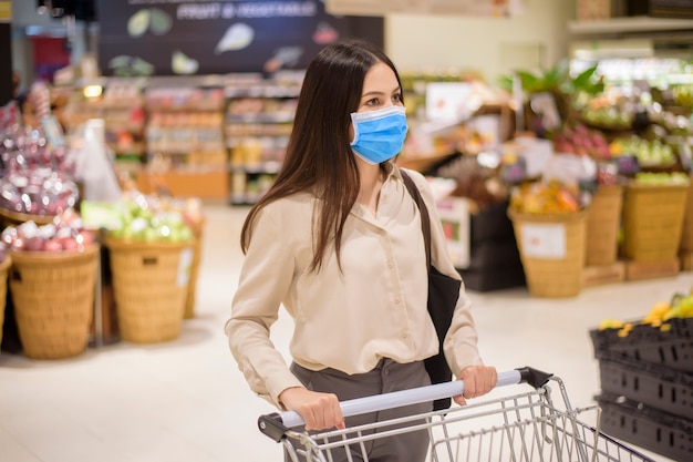 Woman is shopping in supermarket with face mask