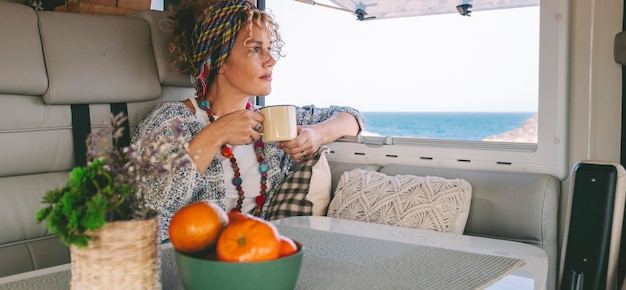 A woman is sitting in a boat with a bowl of fruit and a cup of coffee.