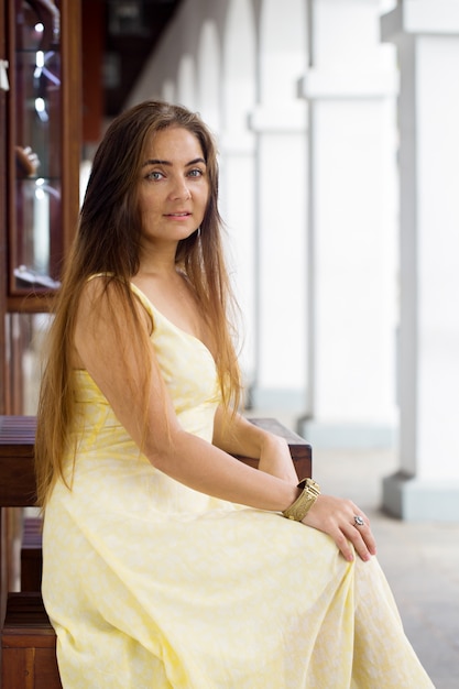 A woman is sitting in a colonnade