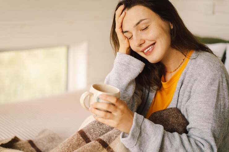 Photo 女性は快適な部屋に座ってコーヒーを飲みリラックスした朝に本を読んでいます