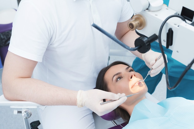 A woman is sitting in a dental chair at a dentist's reception.