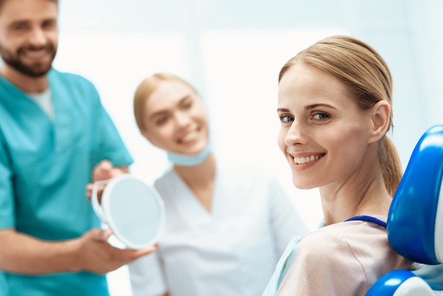 Una donna è seduta in uno studio dentistico su una sedia dentale.