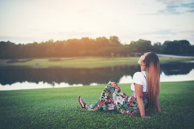 woman is sitting at the lake relax time