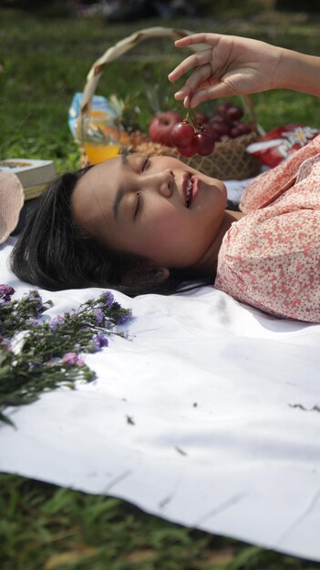 Photo a woman is sleeping in front of a display of fruit.