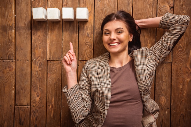 Woman is smiling while lying on wooden floor.