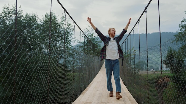 Foto una donna è in piedi su un ponte con le braccia tese.