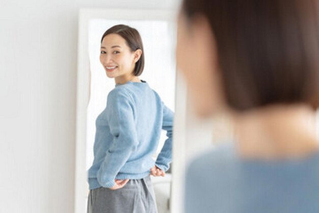 Photo a woman is standing in front of a mirror and the reflection of her shirt is visible
