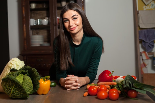 野菜たっぷりのテーブルの近くに立っている女性