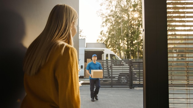 Photo a woman is standing outside of a door with a box in front of her.