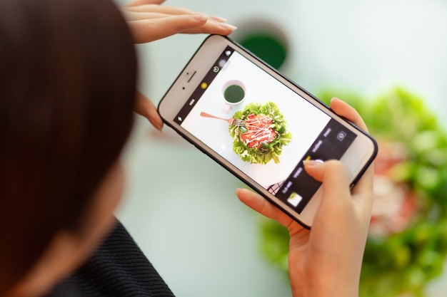 Woman is taking pictures of her meal