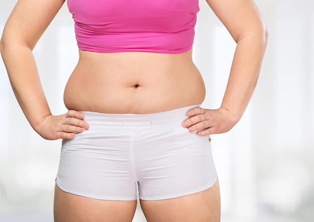 A woman is testing the skin on the thigh for the presence of stretch marks and cellulite