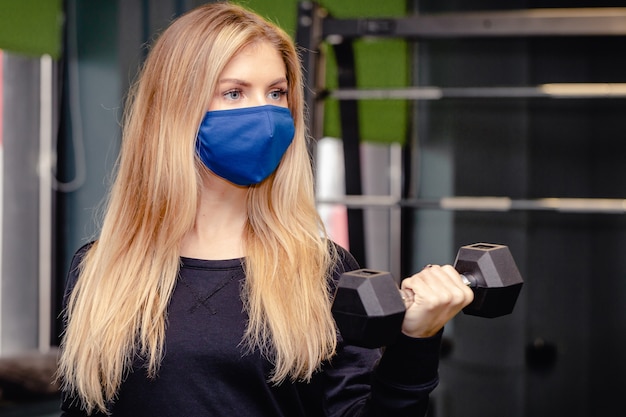 여자는 전염병 동안 체육관에서 훈련입니다.