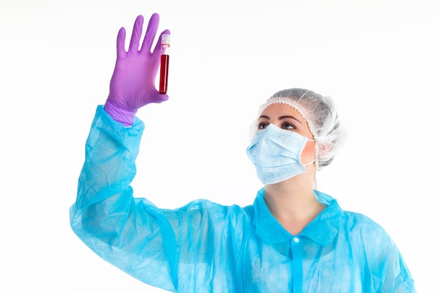 The woman is transfusing from a tube to a flask some liquid on a white background