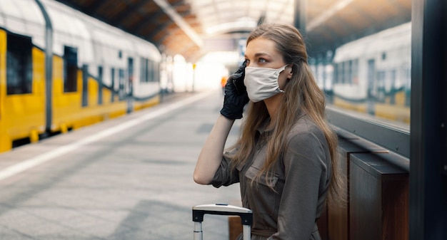 Woman is traveling by train during pandemic with facemask