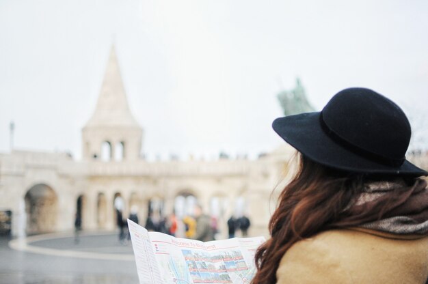 女性は一人で旅行しています。女の子は道を見つけるために地図を見ています。海外旅行。