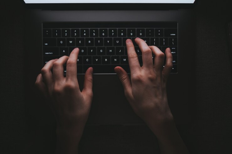 女性はノートパソコンのキーボードで入力しています