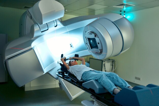 Woman is undergoing radiation therapy for cancer in a modern\
cancer hospital