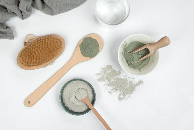 A woman is using a spoon to scoop up powder from a jar.