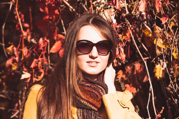 Woman is walking in autumnal park in glasses