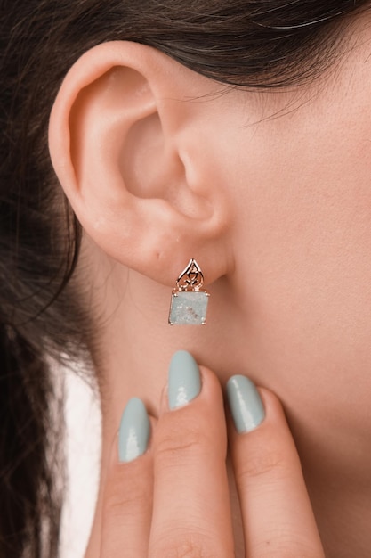 a woman is wearing a diamond earring that says  earring