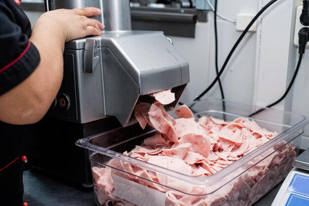 Photo woman is working on meat grinder machine forcemeat process for making sausages