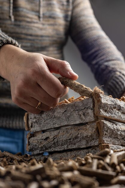 A woman is working on a stack of wood and is holding a piece of wood.