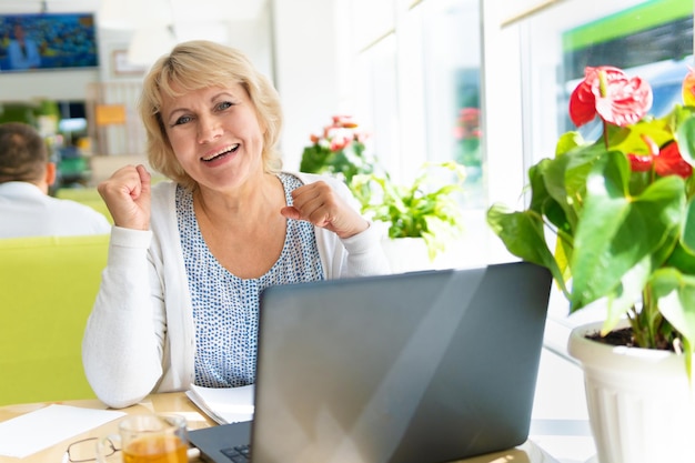 A woman is working with a laptop at a table in the room