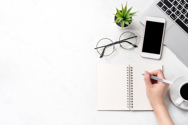 A woman is writing notes isolated on stylized marble office working desk