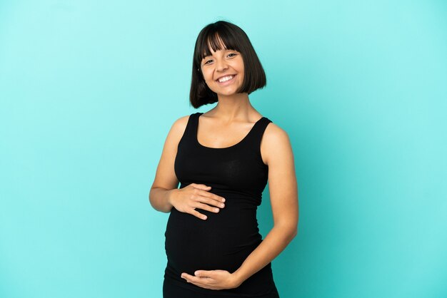 Woman over isolated background pregnant and happy