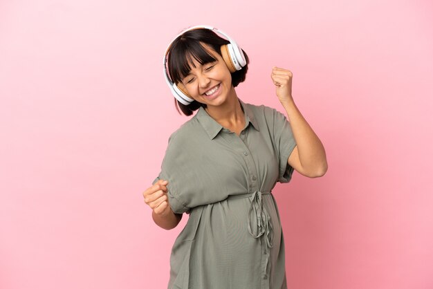 Woman over isolated background pregnant and listening music