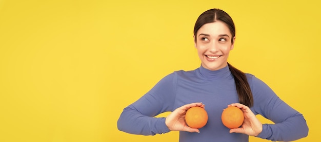 オレンジ色の柑橘系の果物を保持している若い女性を笑顔でコピー スペースを持つ女性分離顔ポートレート バナー