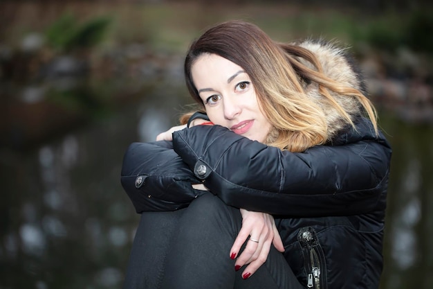 Donna in una giacca su uno sfondo di natura