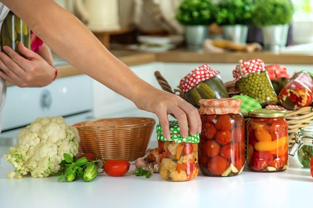 Foto barattolo donna conservare le verdure in cucina messa a fuoco selettiva