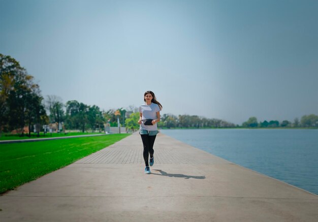 woman jogging in park with lake view wearing sportswear