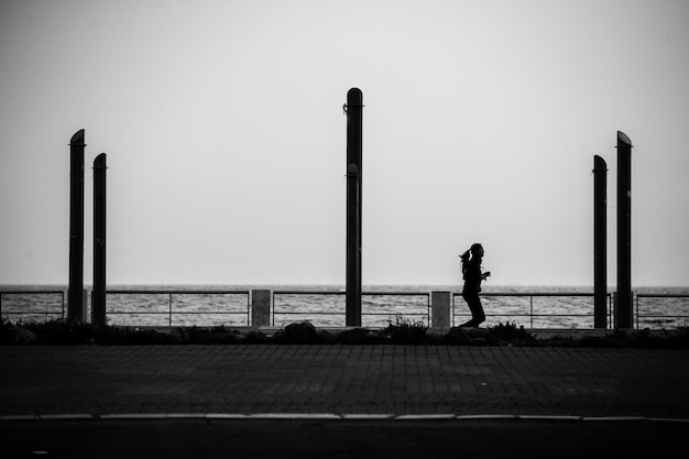 Photo woman jogging on promenade against sky