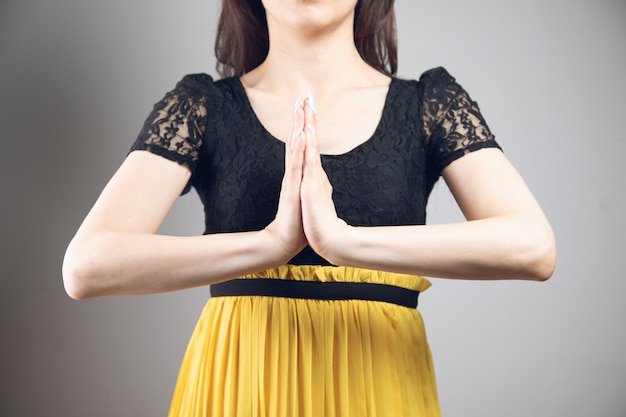 Woman joined palms in dress