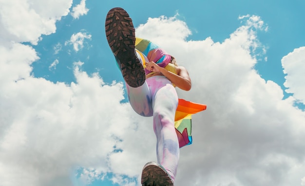 Woman jumping with a rainbow gay pride flag