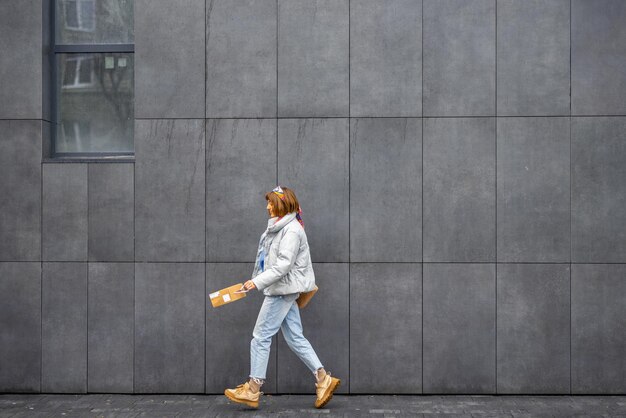 Woman jumps while walking near the wall outdoors