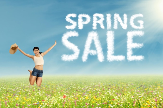 Photo woman jumps with spring sale sign