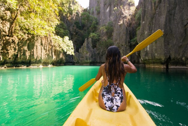 Photo woman kayaking in the small lagoon in el nido, palawan, philippines - travel blogger exploring south-east asia best places