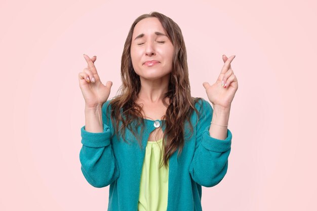 Woman keeping fingers crossed hoping for good luck