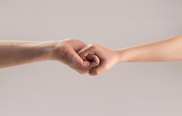 Woman and kid hands connect with each other Friendly handshake friends greeting Rescue helping hand Man help hands protection Male and child hands connected each other together and forever