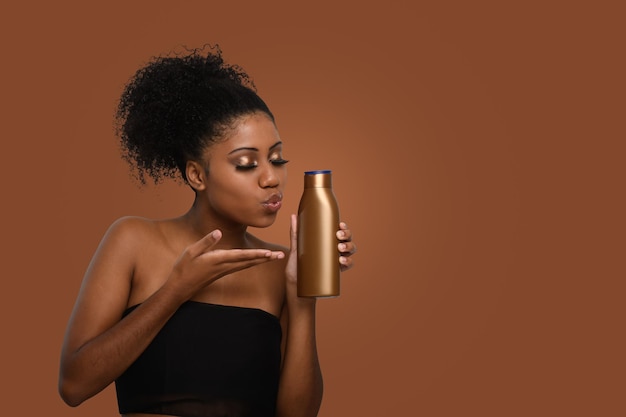 a woman kisses an unlabeled bottle of moisturizing cream demonstrating skin care isolated in a brow