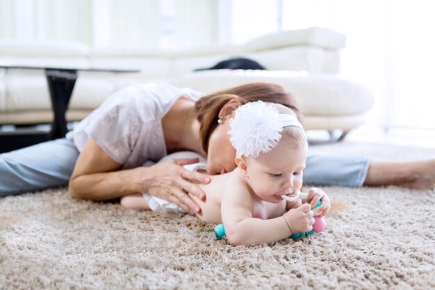 Photo woman kissing daughter on carpet at home