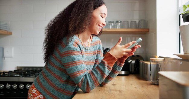 写真 女性キッチンで電話でタイピングしたり家庭でソーシャルメディアをブラウジングしたり週末に幸せでリラックスしたりオンライン会話ユーモア笑いを楽しむための女性人間のコミュニケーションとモバイルアプリケーション - ガジェット通信 getnews