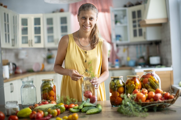 Woman in the kitchen canning vegetables