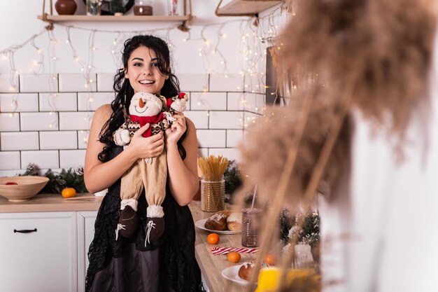 Woman on kitchen hold snowman toy