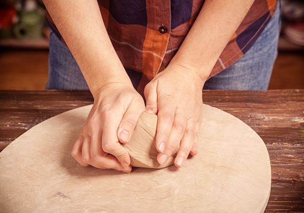 Woman kneads the clay