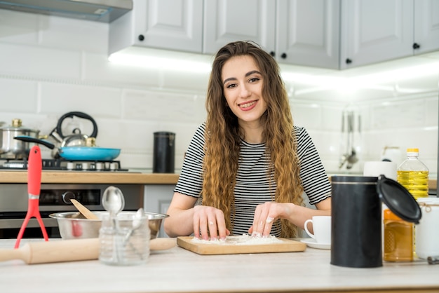 Woman kneads the dough with different ingredient